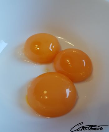 Three yellow egg yolks in a bowl
