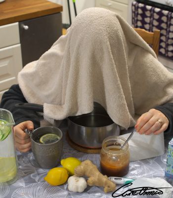 Person under a towel with a myriad of home remedies