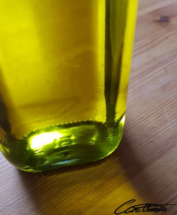 Bottle of olive oil on wooden surface